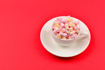 Fototapeta na wymiar Cup with marshmallow on a red background. Copy space.