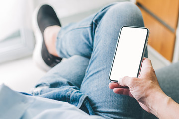 Mockup image blank white screen cell phone.woman hand holding texting using mobile on desk at coffee shop.background empty space for advertise text.people contact marketing business,technology 