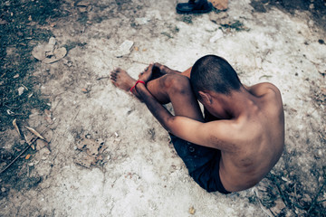 poor child or beggar begging you for help sitting at dirty slum. concept for poverty or hunger...