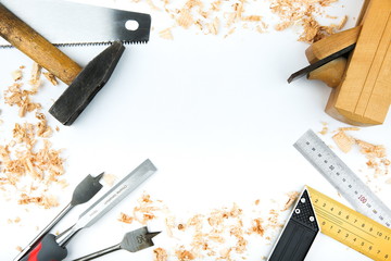 carpentry tools with wood shavings on a white background flat lay