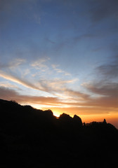 Huangshan Mountain in Anhui Province, China. Sunset over Huangshan with colorful sky and clouds and a silhouette of the mountain. Portrait. Sunset near the summit of Huangshan Mountain, China.