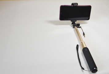 A set for a blogger. On a white background smartphone and selfie stick for photo and video.