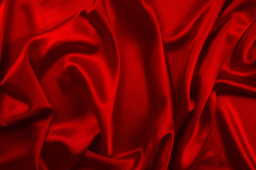 Red silk or satin luxury fabric texture can use as abstract background. Top view.