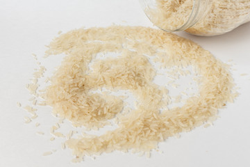 Long white rice on a white background. Spilled from a jar.