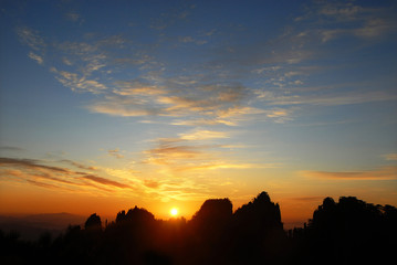 Huangshan Mountain in Anhui Province, China. Sunrise over Huangshan with a colorful sky, clouds and silhouette of the mountain. Sunrise near the summit of Huangshan Mountain, China.