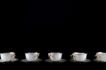 line of cups on a black background with copy space