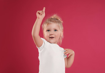 Portrait of emotional little girl on pink background