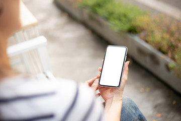 Mockup image blank white screen cell phone.woman hand holding texting using mobile on desk at coffee shop.background empty space for advertise text.people contact marketing business,technology 