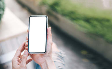 Mockup image blank white screen cell phone.woman hand holding texting using mobile on desk at coffee shop.background empty space for advertise text.people contact marketing business,technology 