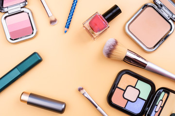 Flat view of cosmetics - lipstic, face-powder, brushes, nail polish.