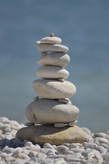 Keep the balance.... a carefully stacked tower of pebbles on a stone beach  