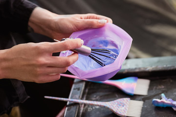 Fototapeta premium Hairdresser colorist kneads paint for hair dyeing.