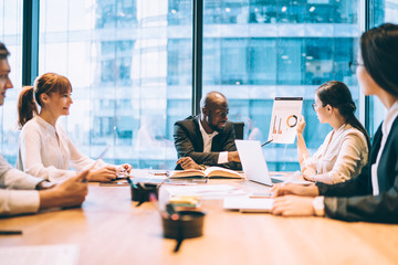Multiracial coworkers analyzing graph in office