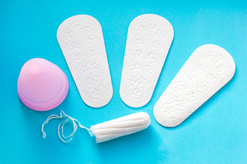 Sanitary pad, menstrual cup and tampon on pink background