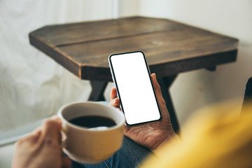 Mockup image blank white screen cell phone.woman hand holding texting using mobile on desk at coffee shop.background empty space for advertise text.people contact marketing business,technology 