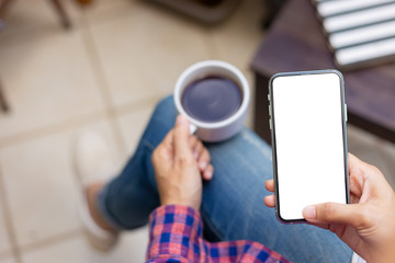 Mockup image blank white screen cell phone.woman hand holding texting using mobile on desk at coffee shop.background empty space for advertise text.people contact marketing business,technology 