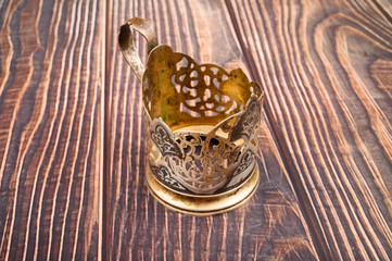 Glass in a metal Cup holder on a wooden background. Close up.