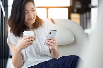 Fototapeta premium korzystanie z telefonu komórkowego. ręka trzyma wiadomość tekstową na ekranie mobilny przyjaciel na czacie, wyszukiwanie informacji w Internecie siedząc na kanapie w biurze. urządzenie technologiczne kontakt komunikacja łącząca koncepcję ludzi