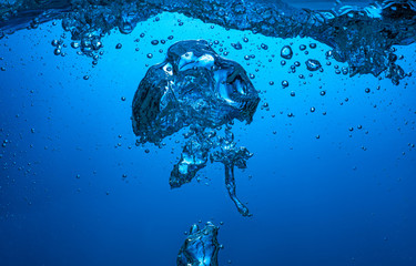 large air bubbles float into the blue light from the dark