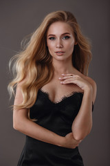 Naklejka premium Beautiful woman in black dress in studio
