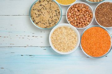 Varieties of natural organic seed in round plates of lentils, chickpeas and long brown rice, buckwheat, millet . the view from the top. space for text. healthy veggie food . diet