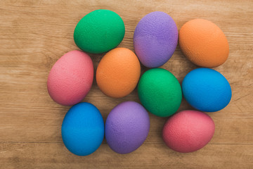 Fototapeta na wymiar top view of rainbow painted Easter eggs on wooden table