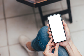 Mockup image blank white screen cell phone.woman hand holding texting using mobile on desk at coffee shop.background empty space for advertise text.people contact marketing business,technology 