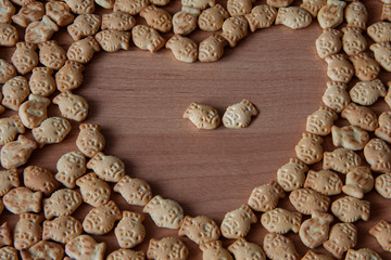 Two cracker fish in the center of a cracker heart shape close up on the table