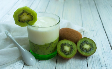  Kiwi smoothie with yogurt on a white wooden background.
