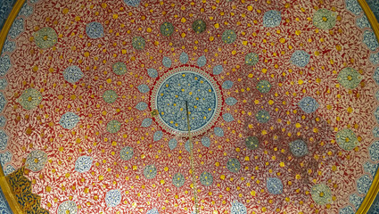 Ground view of the beautifully decorated dome of eastern architecture building with many oriental ornaments and patterns