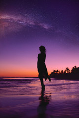 joven mujer contemplando el paisaje anochecer con estrellas
