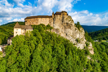 Fototapeta na wymiar Orava castle - Oravsky Hrad in Oravsky Podzamok in Slovakia. Medieval fortress on extremely high and steep cliff by the Orava river. Aerial view in sunrise light in summer