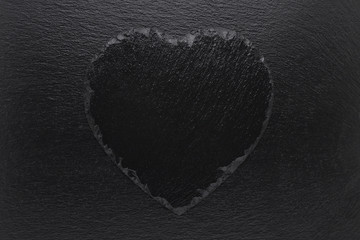 Black heart slate plate on black background