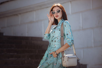 Fototapeta premium Fashion portrait of young stylish woman walking on the street