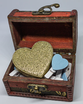 Cofre retro lleno de corazones azules y un gran coraz&oacute;n dorado.