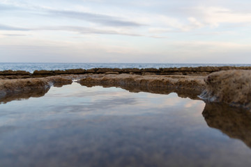 Rock seaside. Stoned beach near sea with blue sky