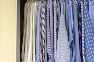 Man shirts in light colurs in wardrobe