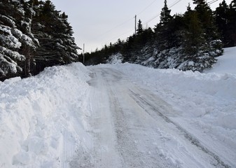 snow covered  road after snow plow has passed in an rural area