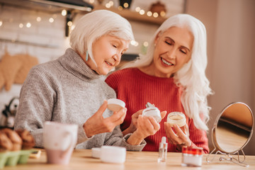 Two good-looking elderly women discussing new creams