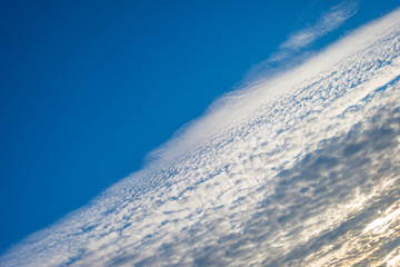 White clouds in a blue sky in sunlight in winter