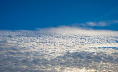 White clouds in a blue sky in sunlight in winter