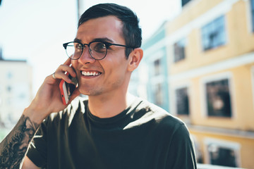Happy man talking to friend on phone in street