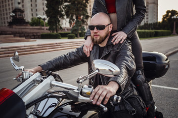 Fototapeta na wymiar Beautiful couple on a cool motorcycle against Moscow