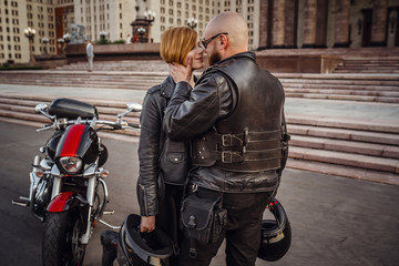 Fototapeta na wymiar Beautiful couple on a cool motorcycle against Moscow