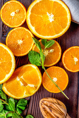 orange juice with mint squeezing on wooden kitchen background top view