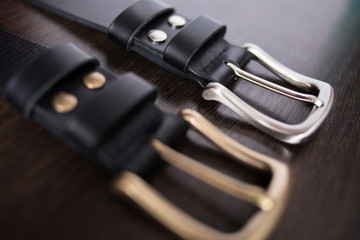 two shiny plaques on a handmade black kazan belt. Shallow depth of field