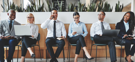 Smiling group of diverse businesspeople working in an office rec