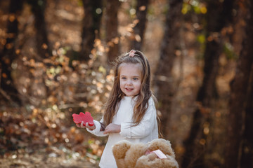 little cute girl and cat in the forest, soft warm light