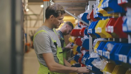 Workers on an automotive spare parts warehouse sorting supplies.