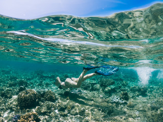 Active female tourist in snorkeling mask dive underwater exploring sea environment searching...